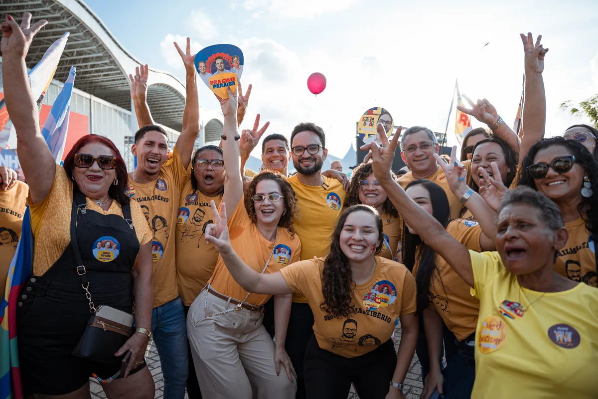 Apoiadores com os braços erguidos durante ato de campanha